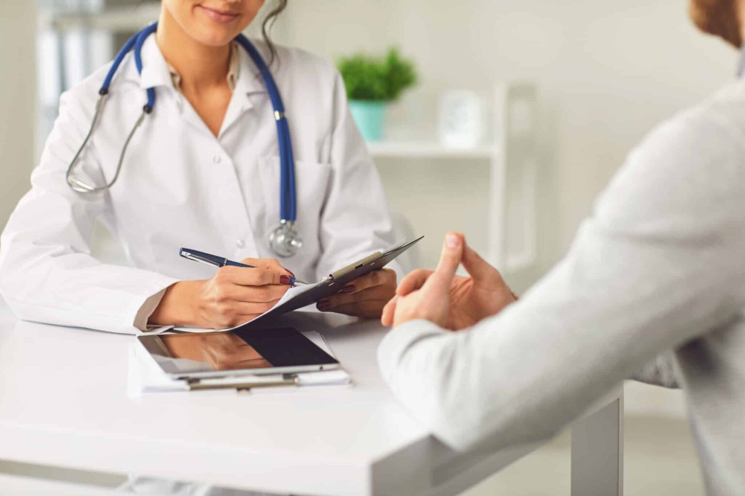 A patient consults with an allergist in an office.