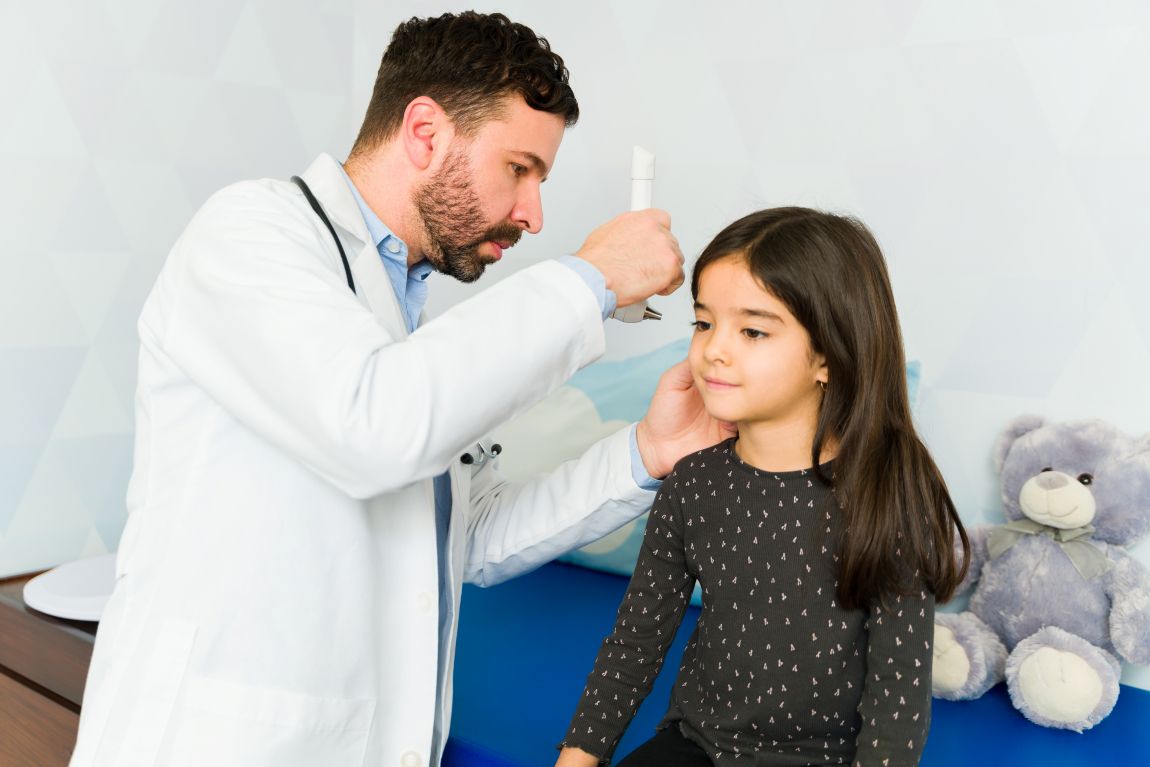 pediatric-ear-infection-symptoms audiologist using otoscope at pediatric appointment to evaluate an ear infection