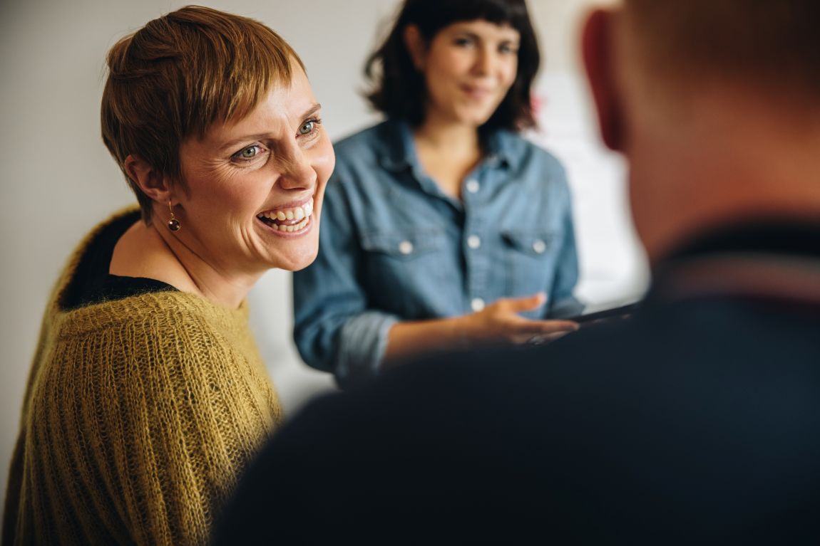 Sore-Throat-symptoms woman smiling in small group