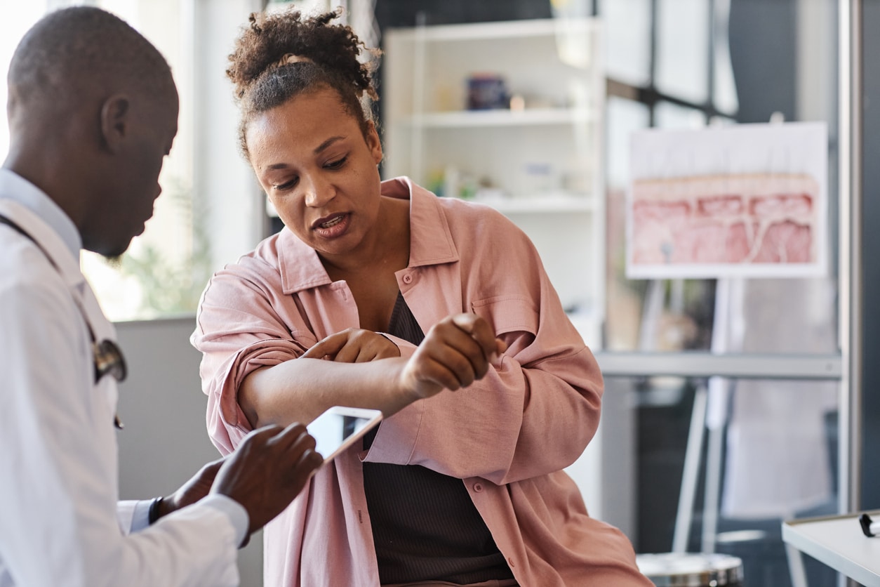 Woman showing her doctor her skin rash